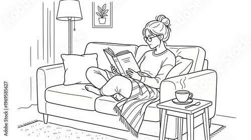 Woman reading a book on a couch with a cup of coffee and a blanket