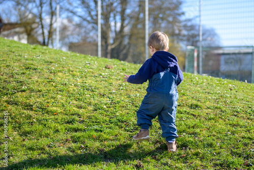 Toddler Walking Across Grassy Hill