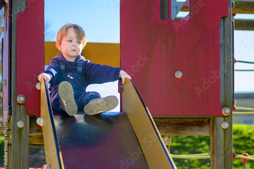 Toddler Sliding Down Playground Slide