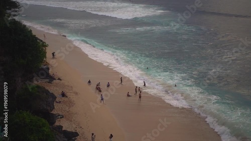 Top View of Sandy Beach with Crowd of People and Turquoise Ocean Waves