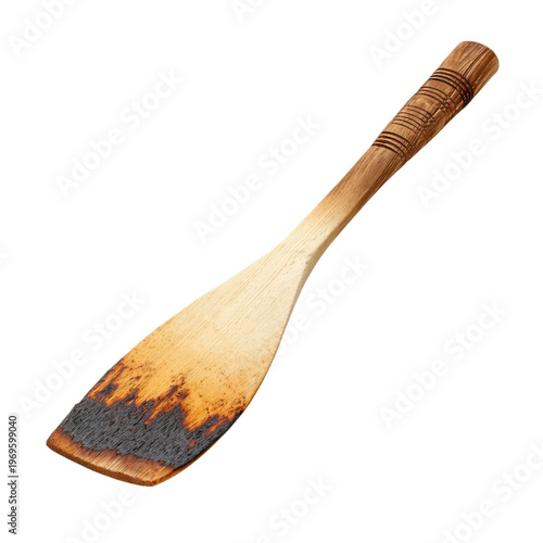 A charred wooden spatula on a black background