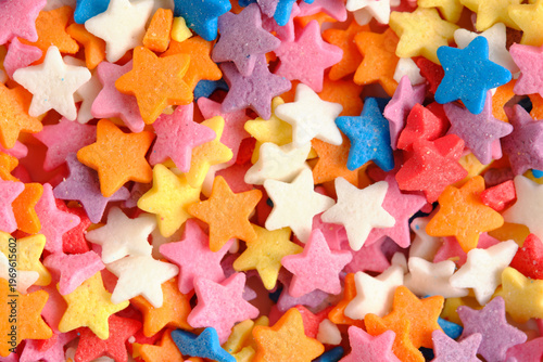 Extreme close up sugar stars in pastel and bright colors, showing fine details sweet confectionery texture.