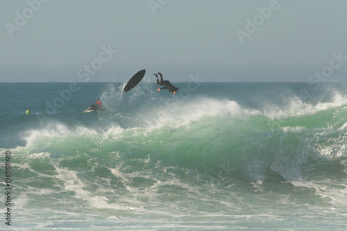фотографія Big wave surfing wipeout in Nazaré, Portugal, surfer falling from board at Praia do Norte