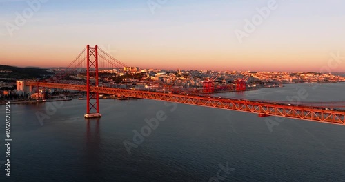 Spectacular sunset over Lisbon Portugal 25th April red suspension bridge famous iconic landmark and skyline