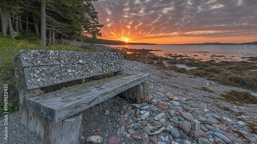 Rustic wooden bench on a pebble beach at sunrise