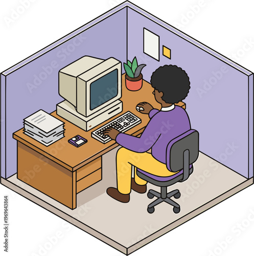 A woman sits at a desk in a small office cubicle working on a computer.