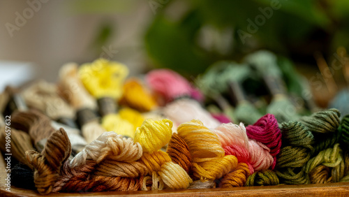Close Up of Colorful Embroidery Floss Threads on Rustic Wooden Table