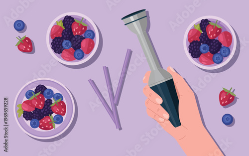 A hand holds a blender amidst bowls of mixed berries including blueberries, raspberries, and strawberries on a table.