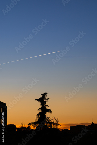 twin engined jet liner aircraft with contrails, in flight at high altitude, clear blue sky