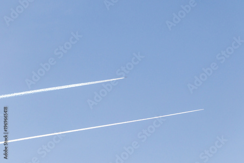 twin engined jet liner aircraft with contrails, in flight at high altitude, clear blue sky