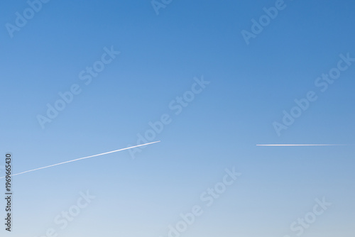 twin engined jet liner aircraft with contrails, in flight at high altitude, clear blue sky