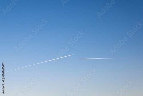 twin engined jet liner aircraft with contrails, in flight at high altitude, clear blue sky
