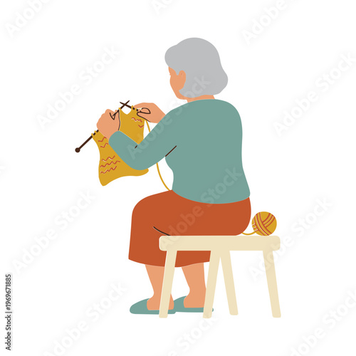 An elderly woman sits on a stool and knits a yellow garment with needles and yarn.