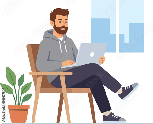 A man sits on a chair with laptop indoors in a relaxed atmosphere.