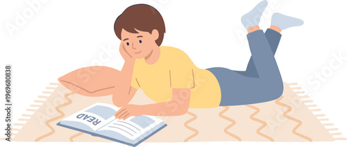 A person reading a book while lying on a rug indoors.