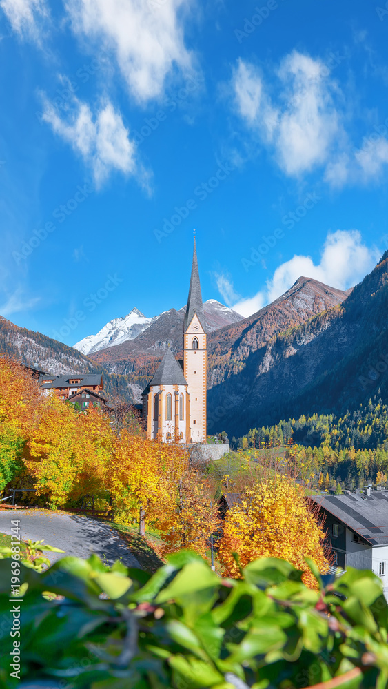 Fototapeta premium Astonishing autumn landscape at Heiligenblut with St Vincent Church near Grossglockner mount .