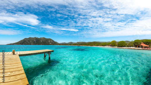 Breathtaking landscape with wooden pier on Santa Giulia beach.