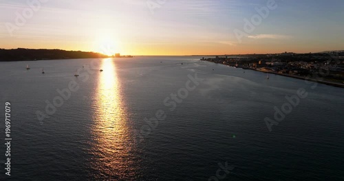 Golden sunset light on Lisbon Portugal 25th April red suspension bridge famous iconic landmark spanning Tagus River