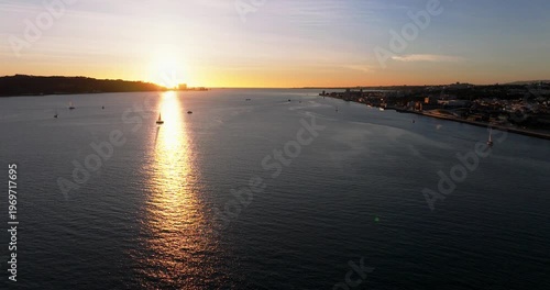 Aerial panorama of Lisbon Portugal 25th April red suspension bridge famous iconic landmark glowing at sunset