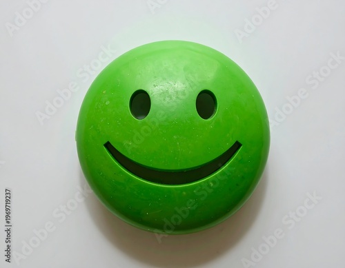 A green rubber ball with a smiley face