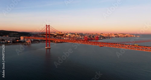 Dramatic sunset sky above Lisbon Portugal 25th April red suspension bridge famous iconic landmark
