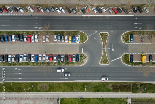 Aerial drone view capturing urban road, moving traffic, and parked cars