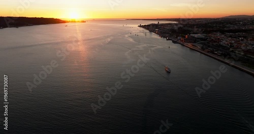 Aerial sunset panorama of Lisbon Portugal 25th April red suspension bridge famous iconic landmark spanning river