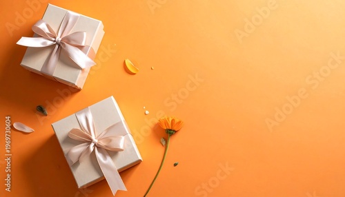 A vibrant orange background with two gift boxes and a flower