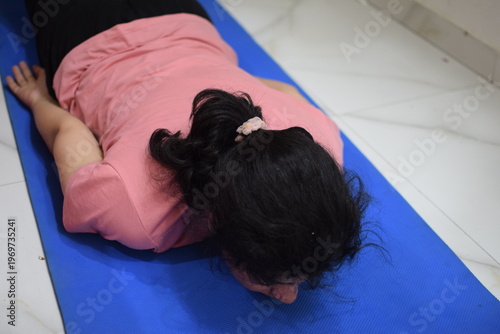 Young Indian woman practicing yoga indoor by online yoga session, Beautiful girl practice basic yoga pose, Asian Indian lady doing indoor yoga