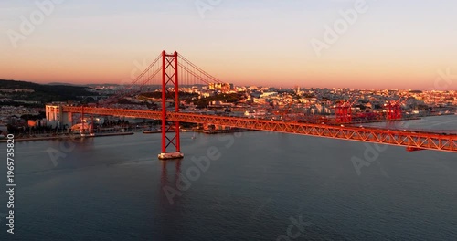 Wide aerial drone sunset perspective of Lisbon Portugal 25th April red suspension bridge, famous iconic landmark
