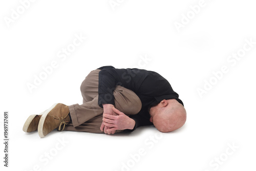 Canvastavla man lying on the ground in the fetal position on white background