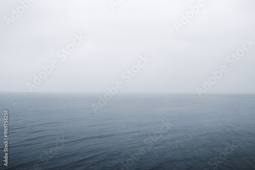 Vast ocean horizon under an atmospheric overcast sky creating a tranquil minimalist seascape