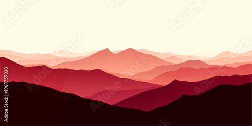 A misty sunset glows over the mountain range as fog settles into the valley below the silhouette of a jagged peak against a cloudy horizon