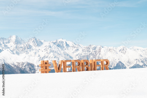 Verbier hashtag sign with snowy mountains