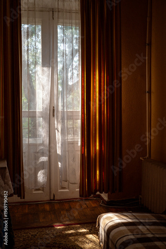 Photography Natural sunlight streaming through a window with white curtains into a retro room