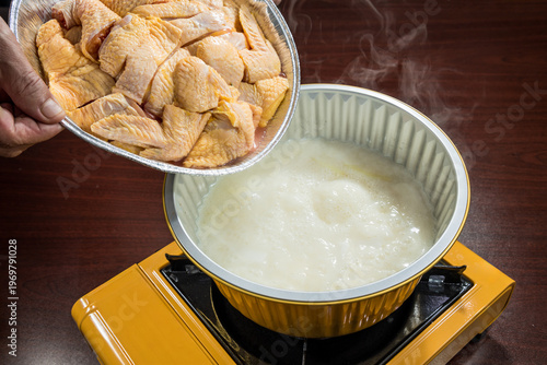 Bubbling chicken broth hot pot at table