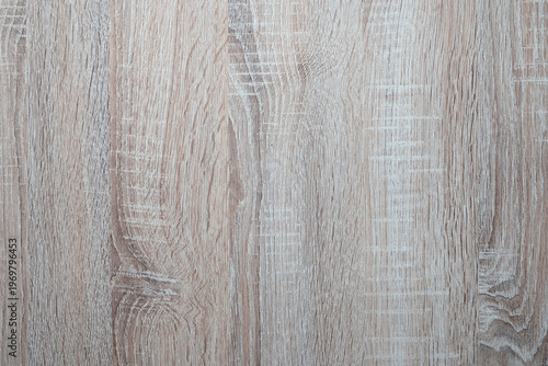 Close-up of weathered wooden surface with natural grain and knots. Textured gray-brown tones show aged character. Ideal for backgrounds, design. Natural wood grain texture
