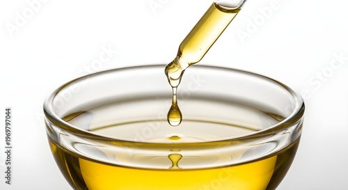 Glass Dropper Dispensing Golden Oil – Holistic Medicine, Natural Remedies and Wellness Concept Isolated on White Background