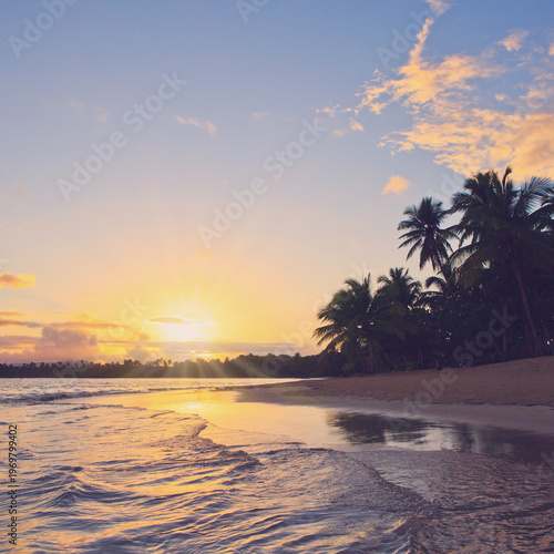 Travel background with Caribbean sunset on tropical beach.