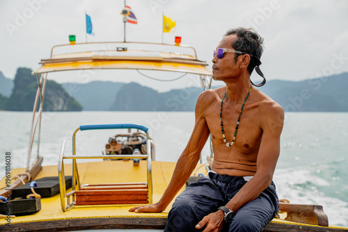 Φωτογραφία Thai longtail boatman navigating tropical sea with islands