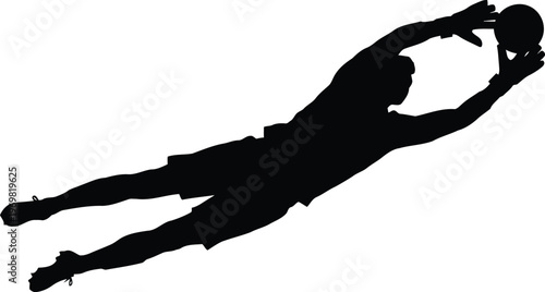 Silhouette of a soccer goalkeeper diving to catch the ball during a game
