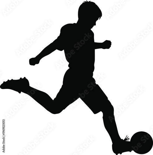 Silhouette of a young athlete in motion kicking a soccer ball during a game