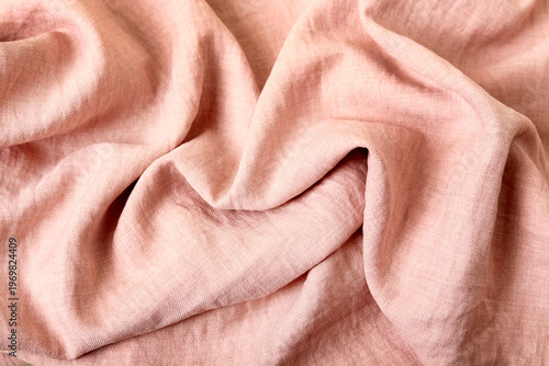Wavy fabric in a shade of pink mixed with peach. Elegant drapery, a background for graphic design projects.