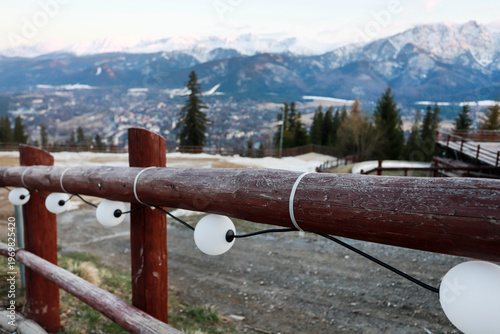 Lanterns hanging on a wooden fence in a mountain village.
