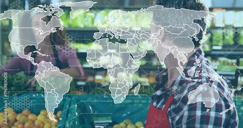 Grocery clerk tapping tablet checking stock causing map hex data over oranges pulling back smiling