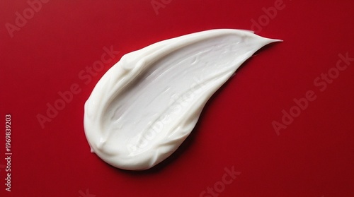 White cosmetic cream smear texture swatch on a red background.