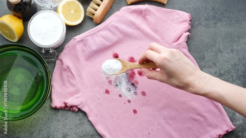 Apply baking soda to remove wine or juice stains from pink clothes in the kitchen. Natural laundry stain removers. top view. 