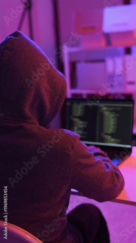 A mysterious hacker working on a computer in a dark room.