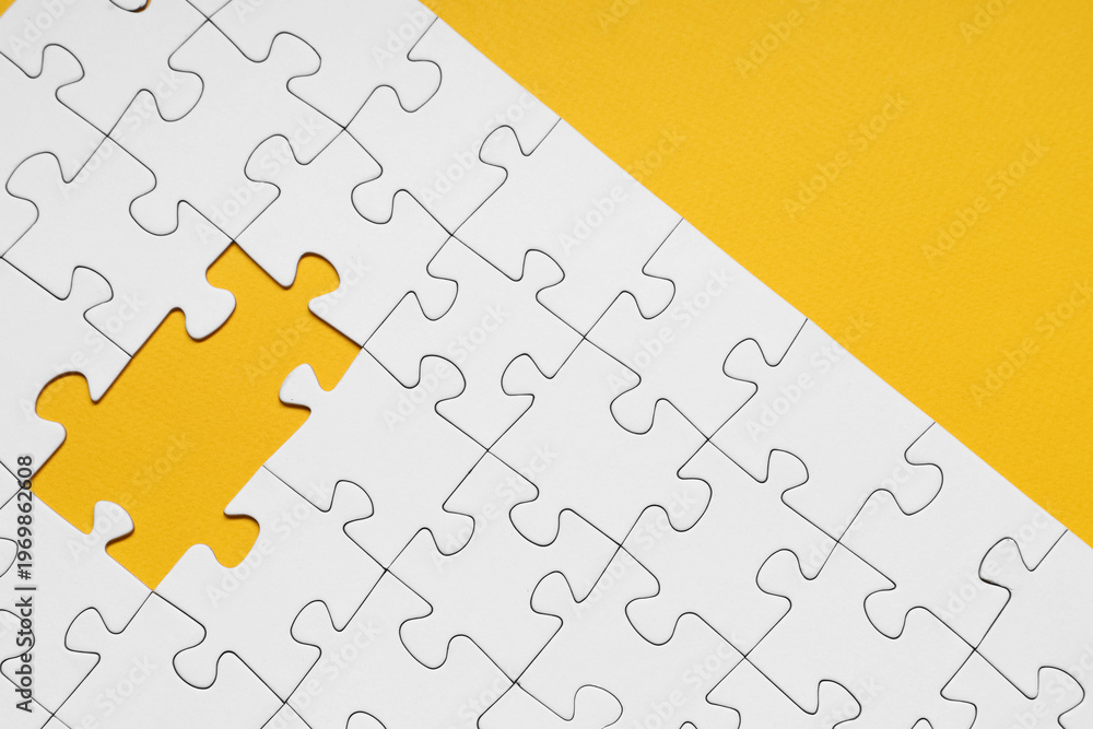 Fototapeta premium White jigsaw puzzle with missing pieces on yellow background