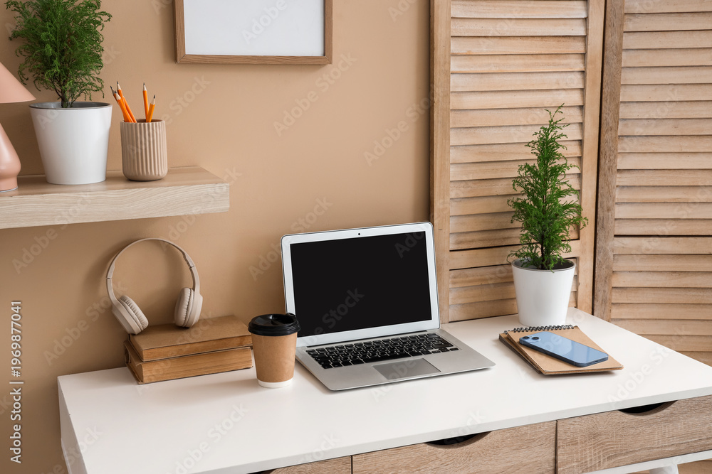Fototapeta premium Interior of office with workplace, wooden folding screen and cypress trees